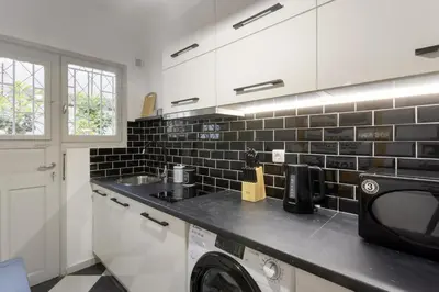 a kitchen with a sink and a washer and dryer at AnapironPolemou5 - Elegance meets charm in a posh in Athens