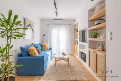 a living room with a blue couch and a table at Luxury Home & Great Location in Athens