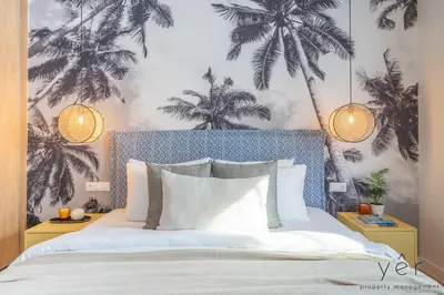 a bedroom with a bed with palm trees on the wall at Luxury Home & Great Location in Athens