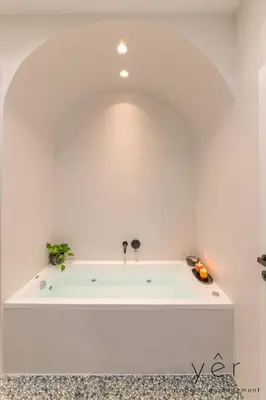 a white bath tub in a white walled bathroom at Luxury Home & Great Location in Athens