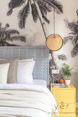 a bedroom with a bed with a palm tree mural at Luxury Home & Great Location in Athens
