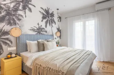 a bedroom with a large bed with palm trees on the wall at Luxury Home & Great Location in Athens