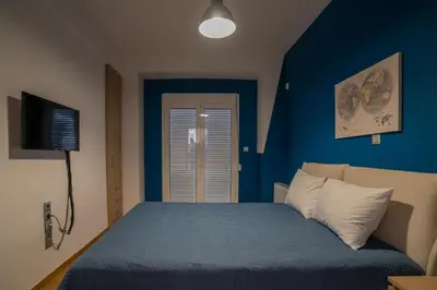 a blue bedroom with a bed and a television at Maxblue 2 in Piraeus