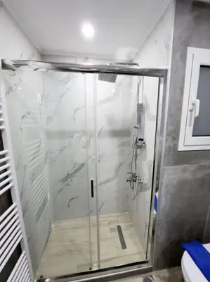 a shower with a glass door in a bathroom at Kipseli's Home VIPGreece in Athens