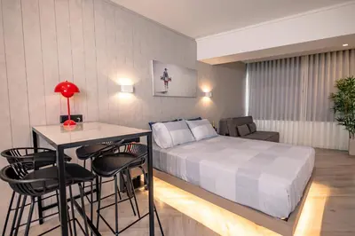 a bedroom with a bed and a table and chairs at Triple A @ Trendy Psiri - Art & Nightlife in Athens