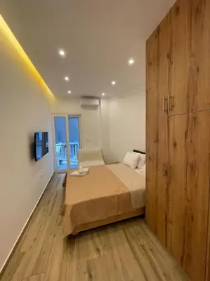 a bedroom with a bed and a large wooden cabinet at Pagrati-Brand new luxury central studio in Athens