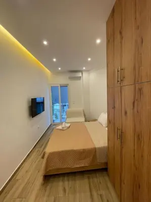 a bedroom with a bed and a large wooden cabinet at Pagrati-Brand new luxury central studio in Athens