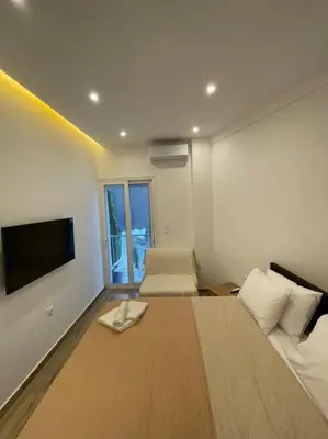 a bedroom with a bed and a flat screen tv at Pagrati-Brand new luxury central studio in Athens