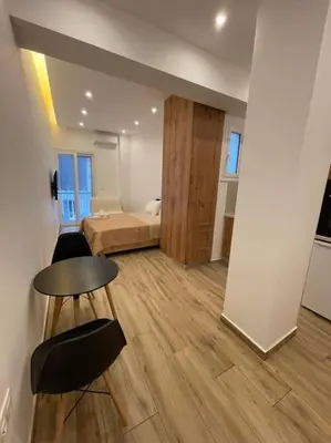 a room with a bed and a table and chairs at Pagrati-Brand new luxury central studio in Athens