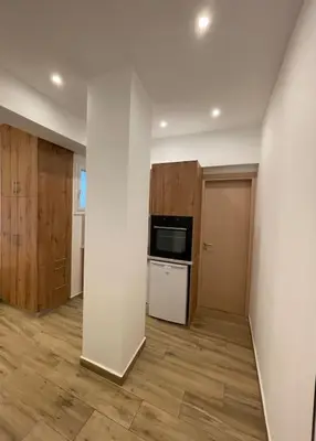 an empty room with a kitchen with a stove and refrigerator at Pagrati-Brand new luxury central studio in Athens