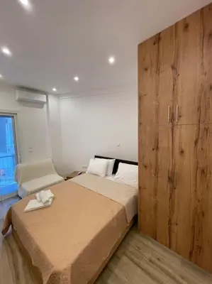 a bedroom with a large bed and a wooden cabinet at Pagrati-Brand new luxury central studio in Athens