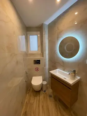 a bathroom with a toilet and a sink and a window at Pagrati-Brand new luxury central studio in Athens