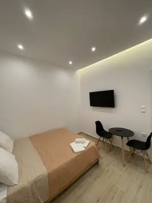 a bedroom with a bed and a table and a tv at Pagrati-Luxury central cozy studio in Athens