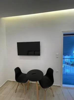 a black table and two black chairs in a room at Pagrati-Luxury central cozy studio in Athens