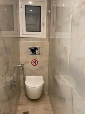 a small bathroom with a toilet and a window at Pagrati-Luxury central cozy studio in Athens