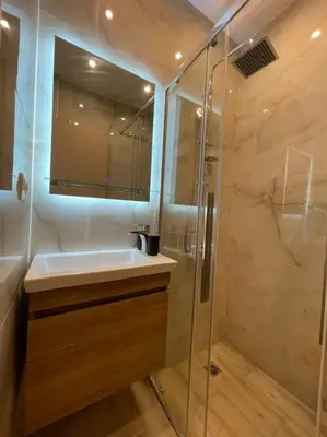 a bathroom with a sink and a glass shower at Pagrati-Luxury central cozy studio in Athens