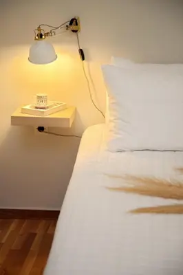 a bed with a lamp on a side table next to it at Aroura Homes 2BR Central Balcony Apt Metro in Athens