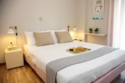 a bedroom with a bed with a tray of food on it at Aroura Homes 2BR Central Balcony Apt Metro in Athens