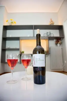 a bottle of wine and two glasses on a table at Aroura Homes 2BR Central Balcony Apt Metro in Athens