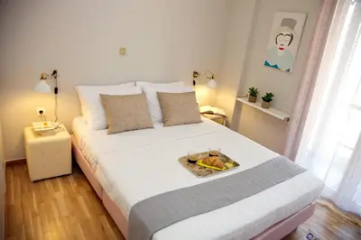 a bedroom with a bed with a tray of food on it at Aroura Homes 2BR Central Balcony Apt Metro in Athens