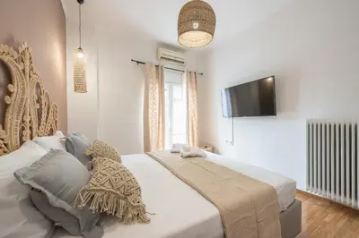 a bedroom with a bed and a tv on the wall at Nomad Pennie Home by CloudKeys in Athens