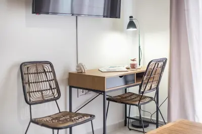 a desk and two chairs in a room at Nomad Pennie Home by CloudKeys in Athens