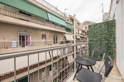 a table and chair on a balcony of a building at Nomad Pennie Home by CloudKeys in Athens