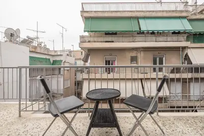 a table and two chairs on a balcony at Nomad Pennie Home by CloudKeys in Athens