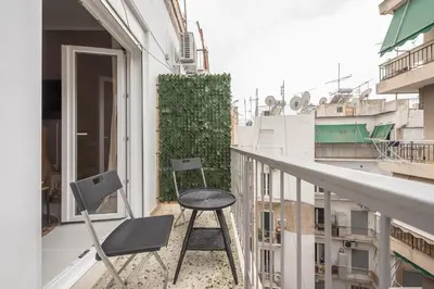 a balcony with a table and chairs on it at Boho Pennie Home by CloudKeys in Athens