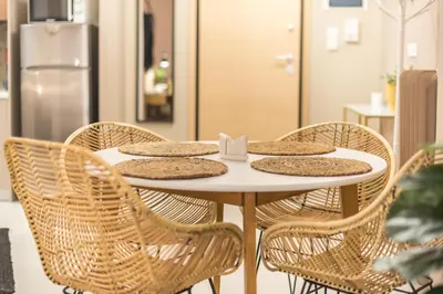 a table with wicker chairs and a table with food on it at Boho Pennie Home by CloudKeys in Athens