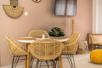 a dining room with a table with wicker chairs at Boho Pennie Home by CloudKeys in Athens