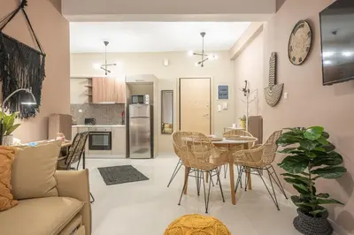 a kitchen and living room with a table and chairs at Boho Pennie Home by CloudKeys in Athens