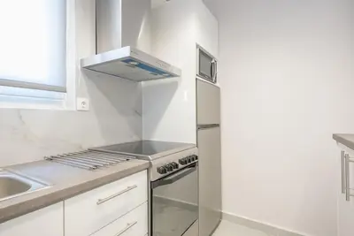 a white kitchen with a stove and a sink at Patisia metro Station 100m in Athens