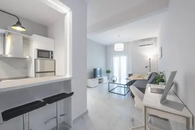 a white kitchen and living room with a couch at Patisia metro Station 100m in Athens
