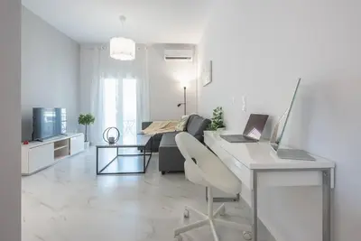 a white living room with a desk with a laptop at Patisia metro Station 100m in Athens