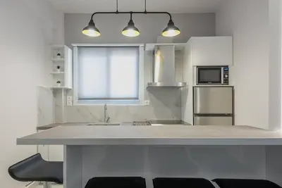 a white kitchen with a counter top and a sink at Patisia metro Station 100m in Athens