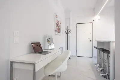 a white office with a laptop on a white desk at Patisia metro Station 100m in Athens