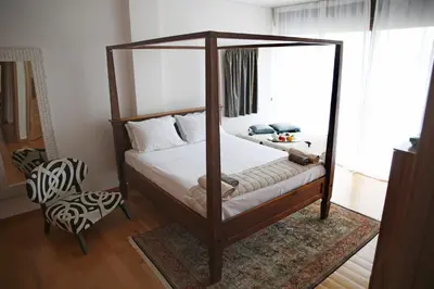 a bedroom with a canopy bed and a chair at Villa 47 in Keratea