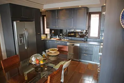 a kitchen with a glass table and stainless steel refrigerator at Villa 47 in Keratea