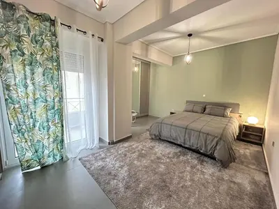 a bedroom with a bed and a large window at New minimal apartment,10' from Athens airport in Spáta