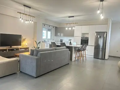 a living room with a couch and a kitchen at New minimal apartment,10' from Athens airport in Spáta