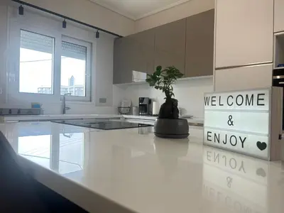 a white kitchen with a potted plant on a counter at New minimal apartment,10' from Athens airport in Spáta