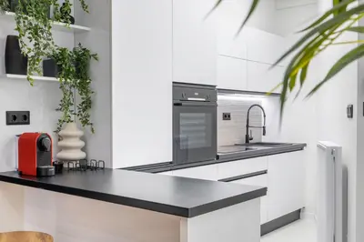 a kitchen with white walls and a black counter top at Luxury Studio Apartment in the Heart of Athens in Athens