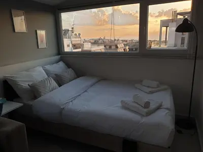 a bed in a room with a large window at Skyline oasis rooftop in Athens