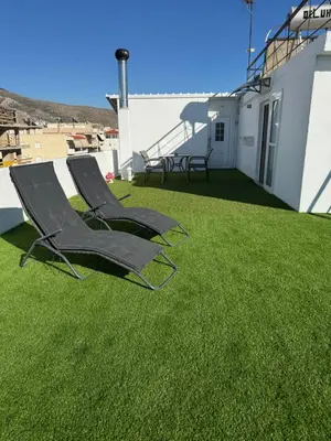 two lawn chairs sitting on the roof of a house at Skyline oasis rooftop in Athens