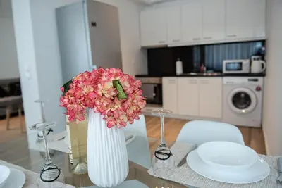 a vase filled with pink flowers on a glass table at Bright 2BR apartment in Palaio Faliro-(FAL_A1) in Athens