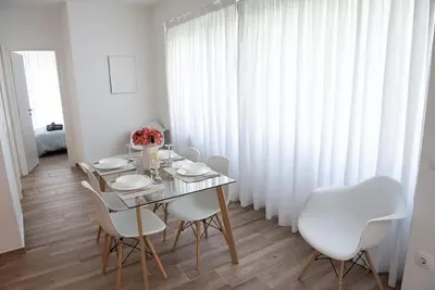 a dining room with a table and white chairs at Bright 2BR apartment in Palaio Faliro-(FAL_A1) in Athens