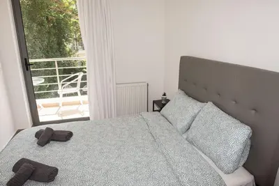 a bedroom with a bed with two slippers on it at Bright 2BR apartment in Palaio Faliro-(FAL_A1) in Athens