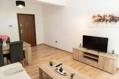 a living room with a television and a table at Renovated spacious flat 7min to subway station-(ΝIK_A) in Athens