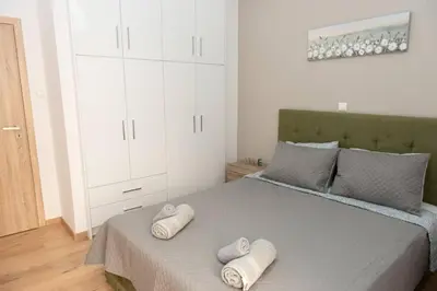a bedroom with a bed with two towels on it at Renovated spacious flat 7min to subway station-(ΝIK_A) in Athens